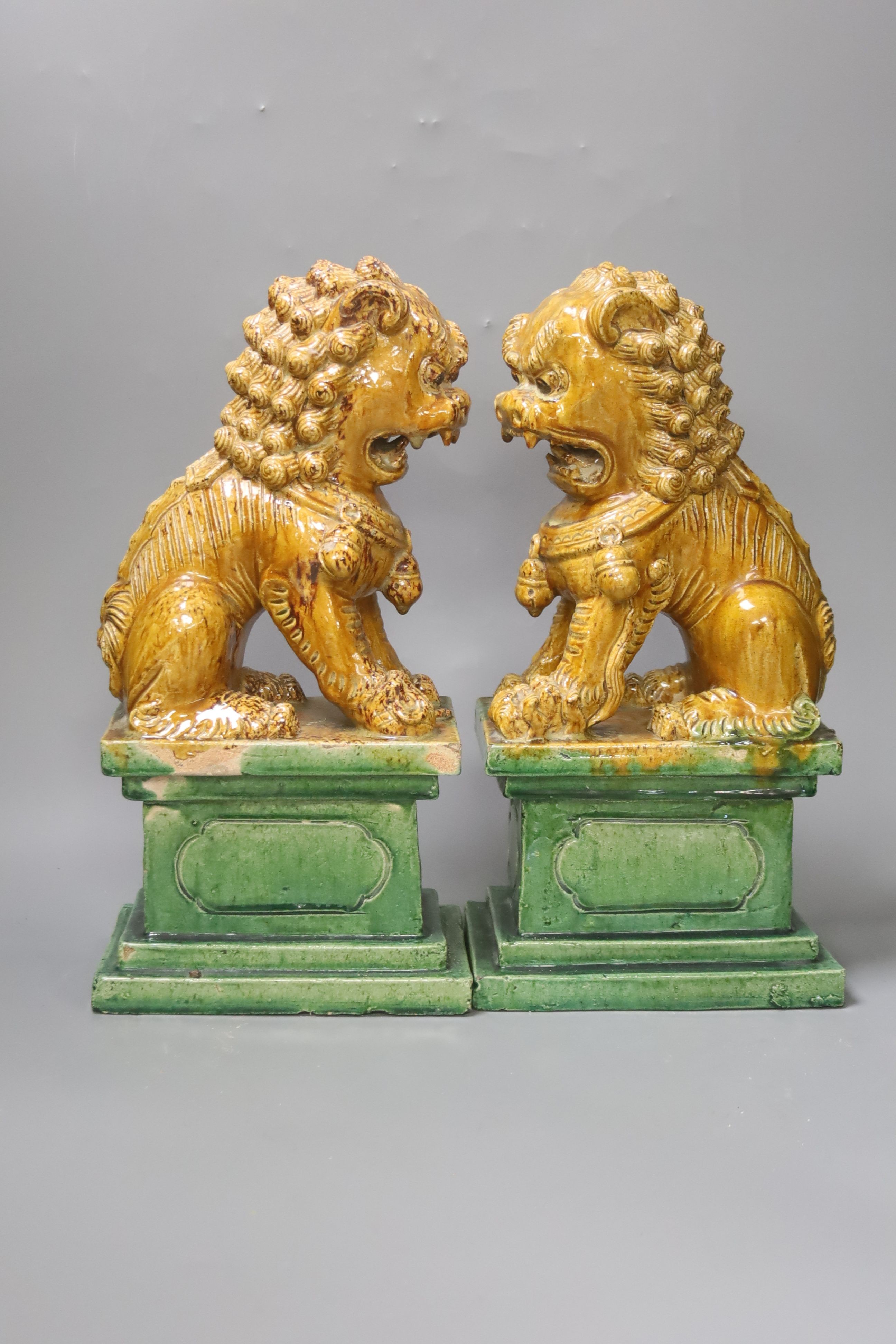 A pair of Chinese Ming style sancai-glazed pottery temple lions, H 35cm